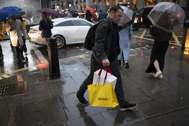 Christmas shoppers and other pedestrians make their way along Piccadilly on a rainy afternoon  in Westminster