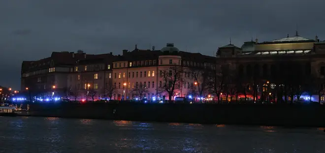 The flashing lights from emergency vehicles are seen along the bank of river Moldau by the Charles University in central Prague, on December 21