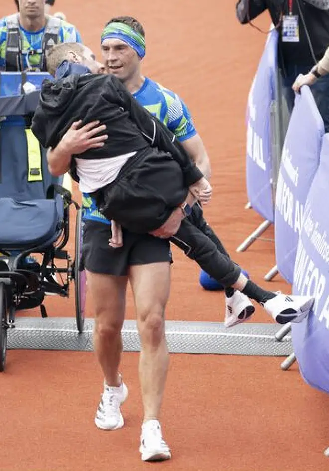 Kevin Sinfield carries Rob Burrow over the finish line of a marathon