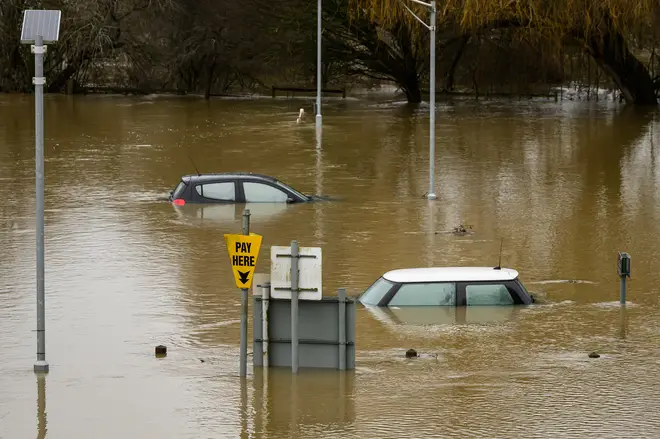 Submerged cars sit in a car park after heavy rains and sewer system overflows caused the River Thames to break its banks