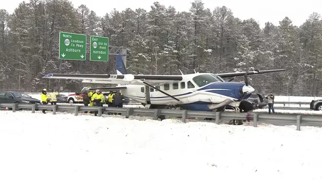 Emergency personnel investigate a small plane on a road in Loudoun County, Virginia