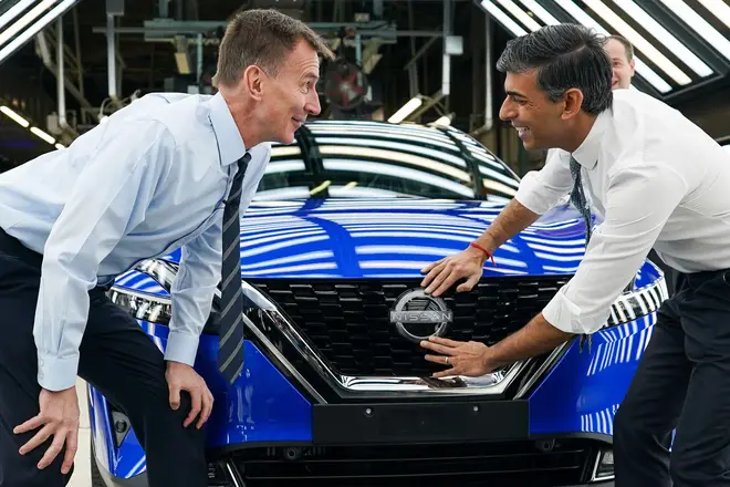 Prime Minister Rishi Sunak and Chancellor of the Exchequer Jeremy Hunt attach a Nissan badge to a car during a visit to the Nissan car plant in Sunderland, November 24, 2023