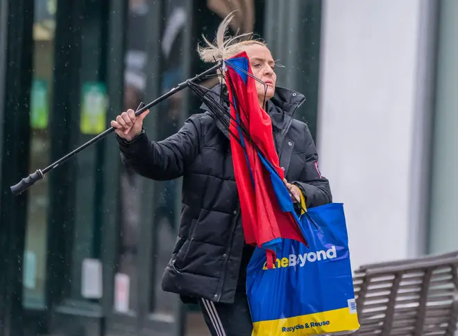A woman with a broken umbrella in windy conditions in Leeds. The UK is blanketed by 'unusual' danger-to-life wind warnings ahead of Storm Isha