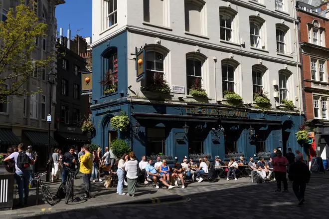 Afternoon drinkers, enjoying the sunshine outside, Glass House Pub, Glass House Street, London, UK.  26 May 2023