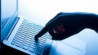 A woman's hand on a laptop keyboard