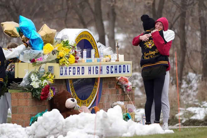 Students hug at a memorial following a shooting at Oxford High School