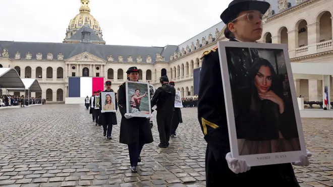 French Republican Guards hold portraits of the French victims of the October 7 2023 Hamas attack, during a ceremony at the Invalides monument