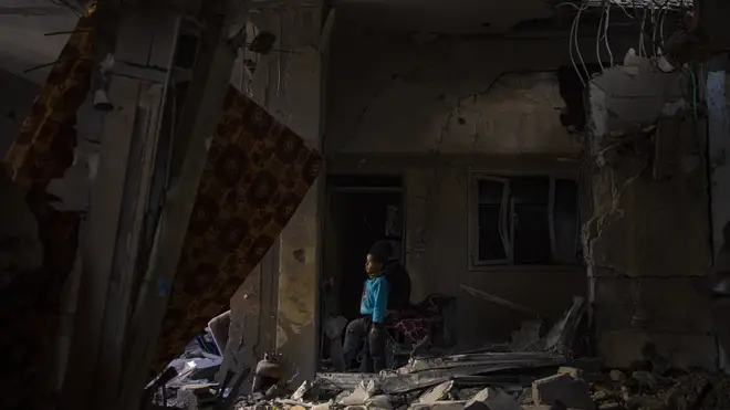 A Palestinian child looks at the damage to his family’s house after an Israeli strike in Rafah, southern Gaza Strip