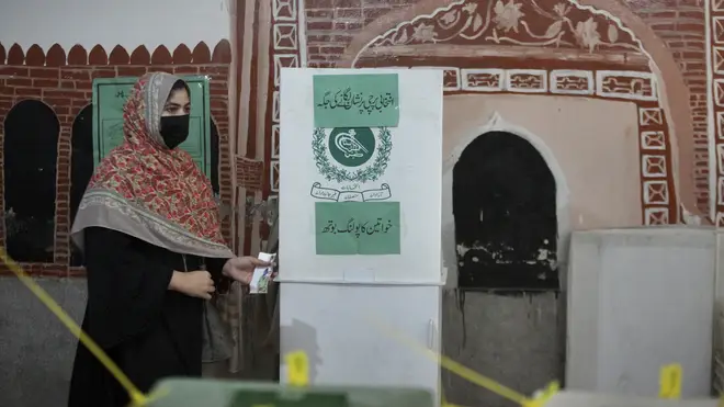 A woman casts her vote at a polling station during the country’s parliamentary elections in Peshawar, Pakistan