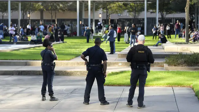 Police officers watch over churchgoers outside Lakewood Church, Texas after a reported shooting during a Spanish church service (Karen Warren/AP)