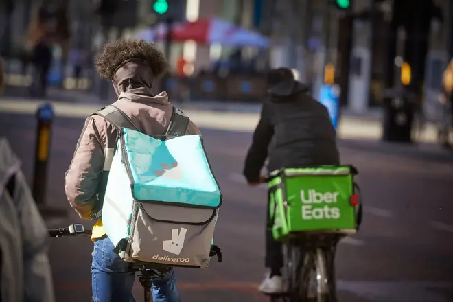 Bike couriers working for online food delivery companies Deliveroo and Uber Eats