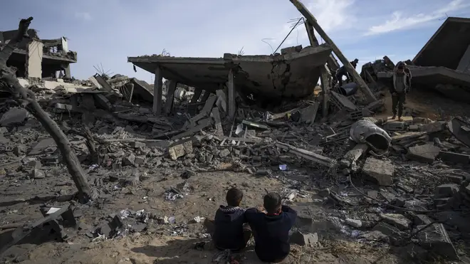 Palestinians inspect the damage after an Israeli raid on Rafah