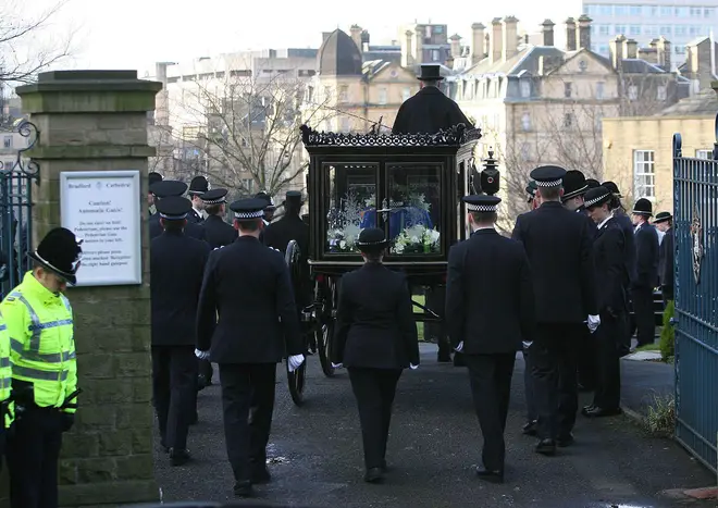 Teresa Milburn (centre), colleague of murdered police officer Sharon Beshenivsky, follows the horse-drawn carriage into the grounds of Bradford Cathedral at the funeral, January 11, 2006