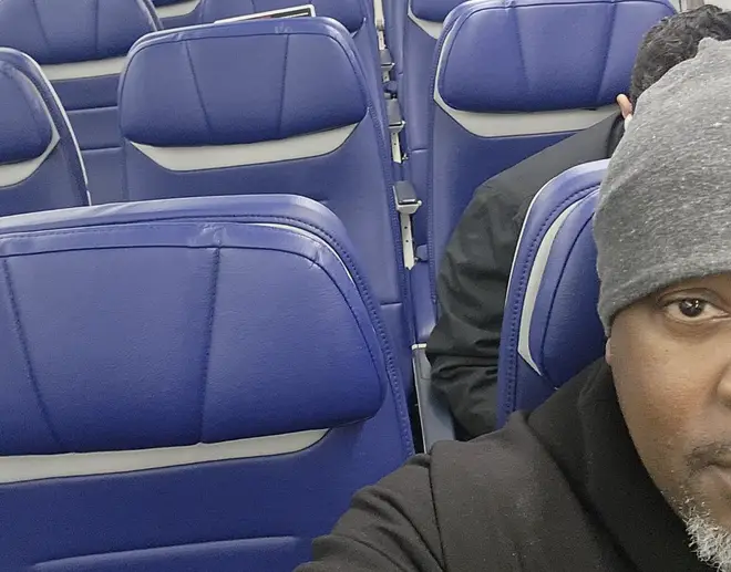 A man sat directly behind his fellow passenger on a nearly empty plane