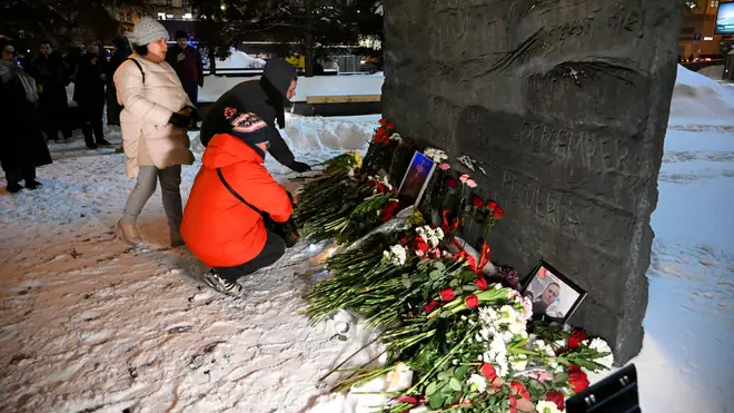 People gather to lay flowers paying their last respect to Alexei Navalny at the at the Wall of Sorrow memorial to victims of political repression in Moscow