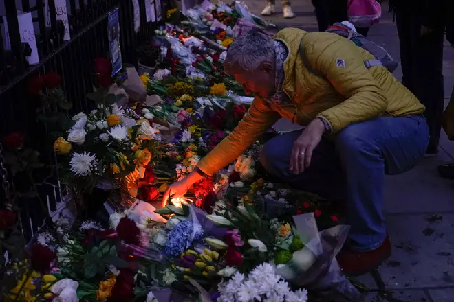 People leave flowers and lit candles opposite the Russian embassy, to commemorate the death of Alexei Navalny in London, Saturday