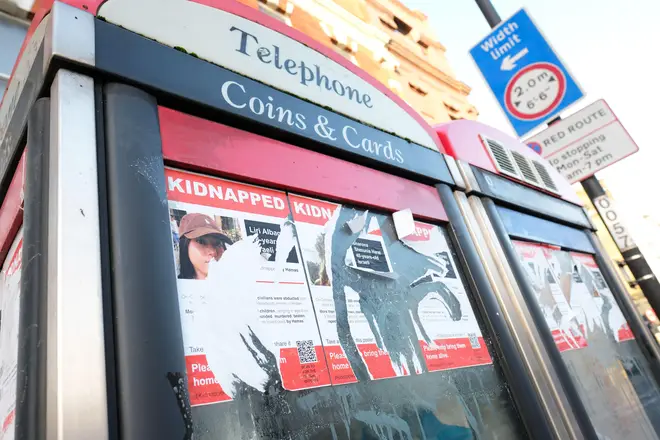 Ripped posters showing kidnapped Israeli victims of the 7th October 2023 attack by Hamas on a north London phonebox - taken January
