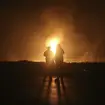 Two men look at flames after a natural gas pipeline explodes outside the city of Boroujen in Iran (Reza Kamali Dehkordi/AP)