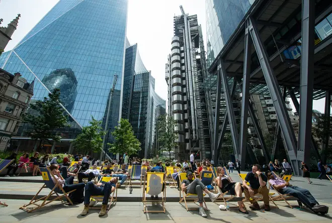 People sit on deckchairs near the Lloyds of London building, London, as more hot weather is due to hit the UK this week.
