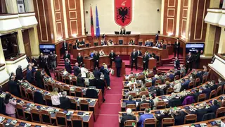 Members of the Democratic Party (left) look on as lawmakers of the ruling Socialist party vote in the Albanian Parliament