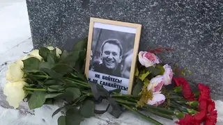 Flowers next to a portrait of Russian opposition leader Alexei Navalny