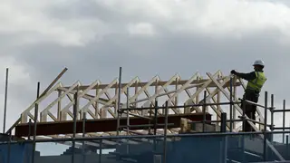 A construction worker builds the roof of a new house