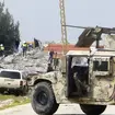 A Lebanese army vehicle blocks a road leading to a warehouse which was destroyed by Israeli air strikes