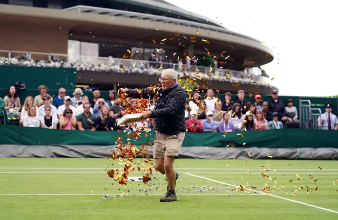 William Ward on Court 18 at Wimbledon throwing confetti onto the grass during Katie Boulter's first-round match against Daria Saville, July 5, 2023