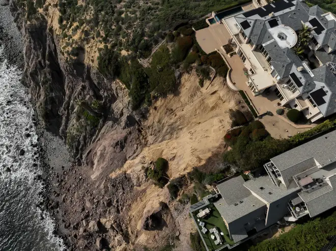 Luxury homes on a Dana Point cliff side are in danger of falling due to a mudslide from heavy atmospheric rainfall.