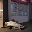 Homeless people sleeping on the pavement outside retails chain stores store along Oxford Street in central London