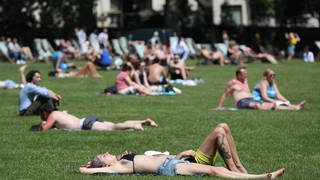 Sunbathers lie on the grass in Green Park, London.