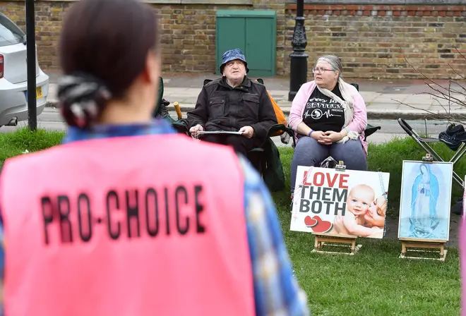 Pro-choice activist stands opposite anti-abortion protesters in Ealing, west London