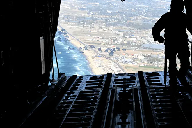 A U.S. Air Force C-130J Super Hercules conducts an airdrop of humanitarian assistance over Gaza, Saturday