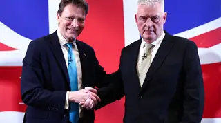 Former Conservative deputy chairman Lee Anderson (R) shakes hands with Leader of Reform UK party Richard Tice (L) as they pose for pictures following a press conference to announce his defection from the Conservative party to Reform UK