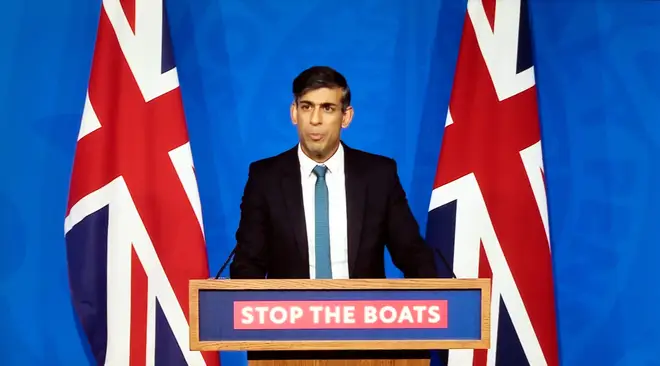 Prime Minister Rishi Sunak standing at podium with Stop the Boats