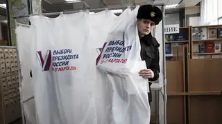 A student leaves a voting booth at a polling station in Russia