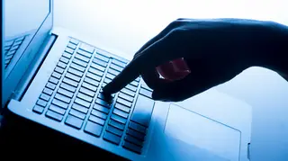 A woman's hand on a laptop keyboard