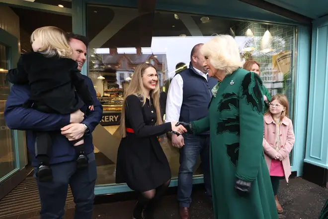 Queen Camilla (centre right) meets the owner of Knotts Bakery, William Corrie, his wife Zoe Salmon and their son Fitz during a visit to Lisburn Road in Belfast to meet shop owners and staff.