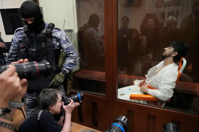 Mukhammadsobir Faizov, a suspect in Friday's shooting at the Crocus City Hall, sits in a glass cage in the Basmanny District Court in Moscow