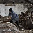 Resident clears rubble from home
