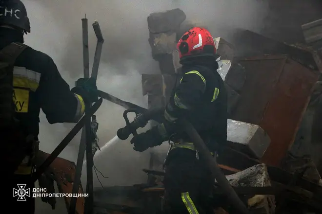 Firefighters respond to flames at a house hit by Russian shelling in Kamiansk, Dnipropetrovsk region