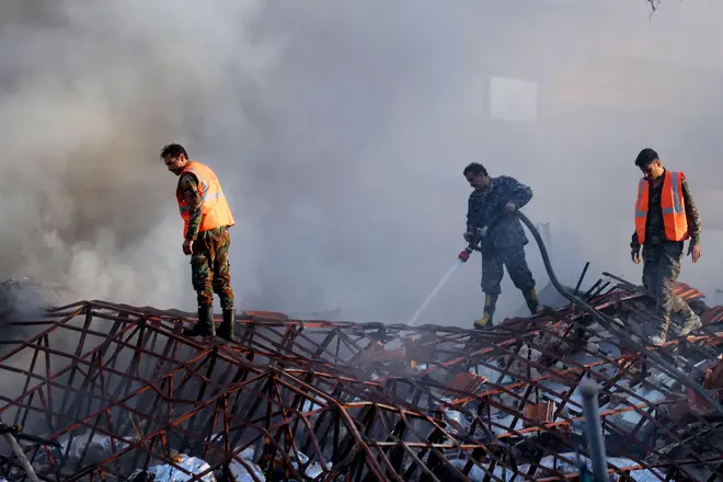 Emergency services work at a destroyed building hit by an air strike in Damascus, Syria, Monday