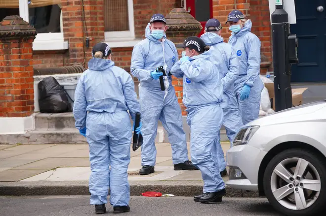 Forensic officers at the scene in Comeragh Road, West Kensington, after a man was shot dead
