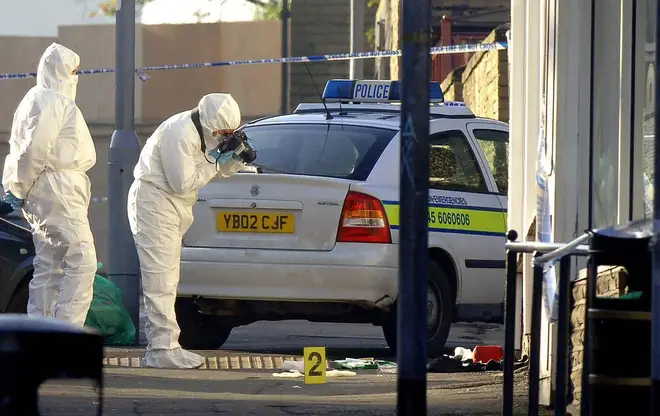 Forensic teams examine the police patrol car used by officer Sharon Beshenivsky, 38, at the scene of her murder in Bradford