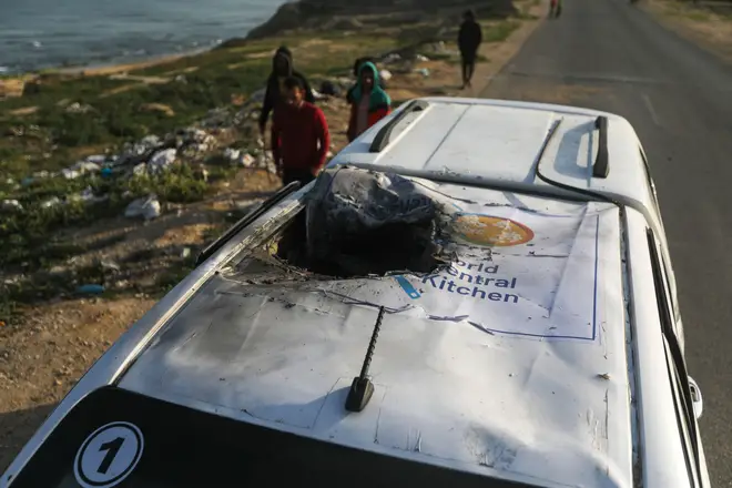Palestinians inspect a vehicle with the logo of the World Central Kitchen wrecked by an Israeli airstrike in Deir al Balah
