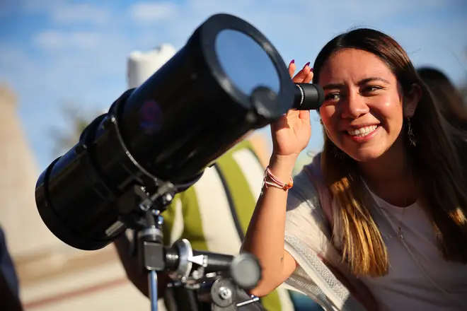 A woman observes the sun with a telescope ahead of this Monday's eclipse on April 07, 2024 in Mazatlan, Mexico