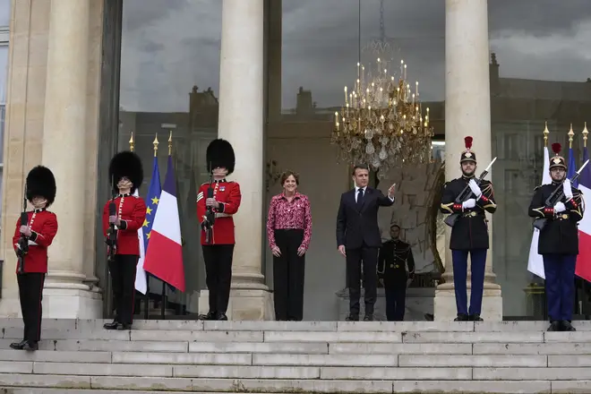 British Ambassador to France Menna Rawlings (C-L) and French President Emmanuel Macron flanked by a member of the the Number 7 Company Coldstream Guards and the Gendarmerie Garde Republicaine, stand on the steps of the Elysee Palace, in Paris