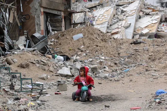 A Palestinian child plays near a building destroyed by earlier Israeli bombardment in Gaza City