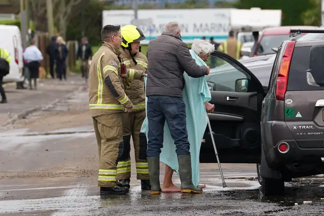 Firefighters evacuate an elderly resident in Littlehampton, West Sussex