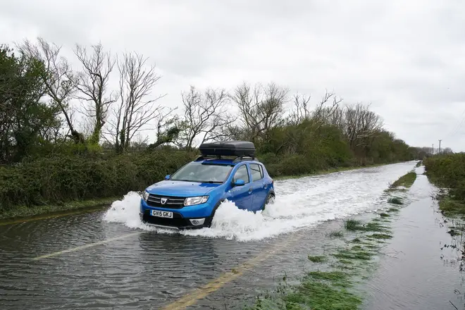 A car drives through flood water in Littlehampton, West Sussex